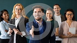 Positive confident male hr extending hand greeting new staff member