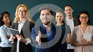 Positive confident male hr extending hand greeting new staff member photo