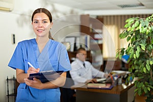 Positive confident young female doctor in a resident's office, writes important notes