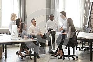 Positive corporate team gather at coworking together discussing new project photo