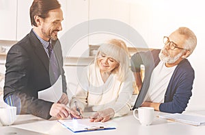 Positive couple signing papers with insurance agent