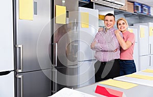 Positive couple standing in store of household appliances