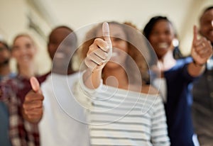 Positive about creating a bright future for themselves. Shot of a diverse group of students showing thumbs up at campus.