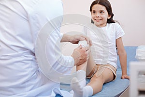 Positive cute girl looking at her doctor