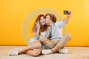 Positive cute people man and woman 20s sitting on floor together