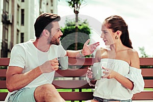 Positive delighted bearded man going to drink coffee