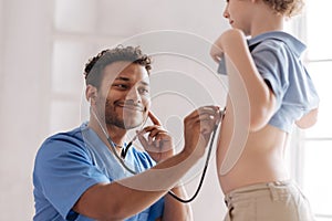 Positive delighted dark-skinned medical worker loving his job