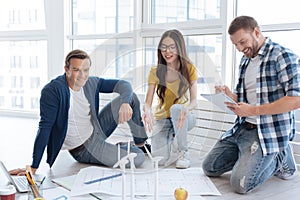 Positive delighted man sitting near his colleague