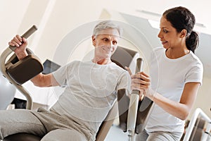 Positive delighted mature man training his arms