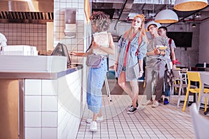 Positive delighted mulatto girl making order on dinner