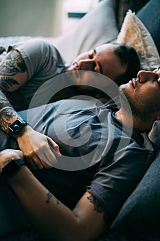 Positive delighted non-traditional couple sleeping together