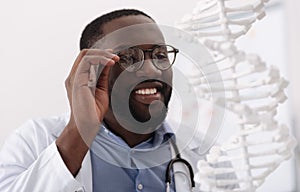 Positive delighted scientist holding his glasses