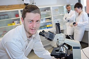 positive delighted scientist looking into microscope