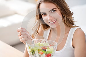 Positive delighted woman eating salad