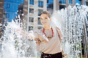 Positive delighted woman feeling splashes of water