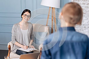 Positive delighted woman psychologist looking at her little patient