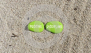 Positive discipline symbol. Concept words Positive discipline on beautiful green stone. Beautiful sand beach background. Business