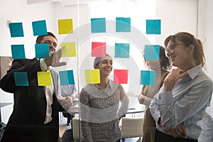 Positive diverse employees brainstorming at briefing using post-it notes