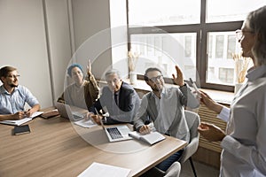 Positive diverse office team asking questions to speaker