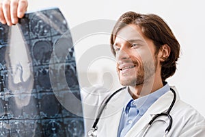 Positive doctor looking at x-ray scans of patient head