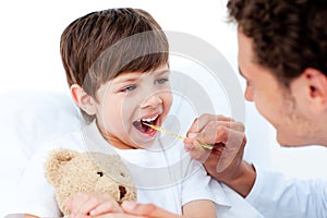 Positive doctor taking little boy's temperature