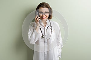 Positive doctor woman talking mobile phone