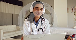 Positive doctor woman in wireless headphones talking on video call