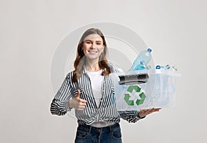 Positive Eco-Friendly Woman Holding Container With Plastic Bottles And Showing Thumb Up