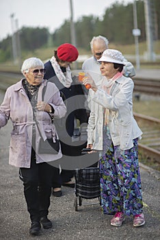 Positive elderly seniors people waiting train before traveling during  pandemic