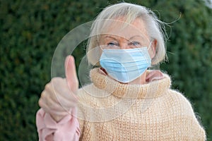 Positive elderly woman giving a thumbs up
