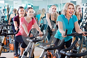 Positive elderly and young women working out hard