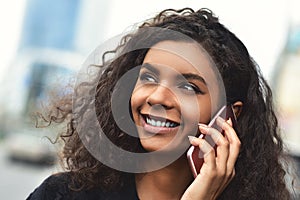 Positive emotions. Lifestyle concept. Close up of young mixed race woman use a phone.