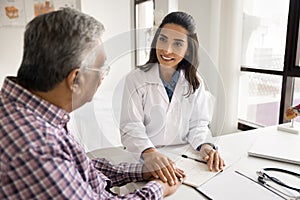 Positive empathetic doctor woman giving support to elderly patient man