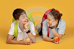 Positive european teenager pupil with backpacks and apples