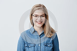 Positive facial expressions and emotions. Attractive caucasian student girl with blonde straight hair in stylish eyewear