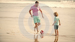 positive family of daddy man and child boy playing ball on beach, fathers day