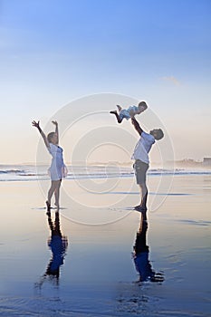 Positive family having fun on black sand sea beach