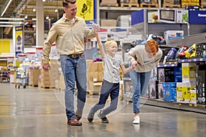 Positive family having fun while choosing things in supermarket