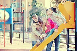 Positive family spending time at children slide