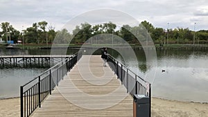 A positive fat woman dances on the bridge of the river in the fall. Mental health.