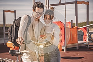 Positive female and her boyfriend smiling watching at mobile phone.tif