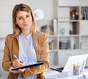 Positive female manager with docs working in white room