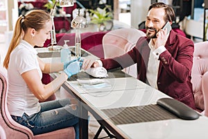 Positive female manicurist doing manicure