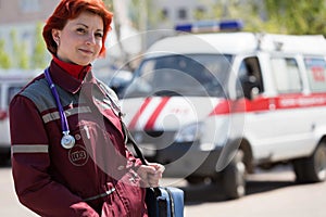 Positive female paramedic with ambulance bag