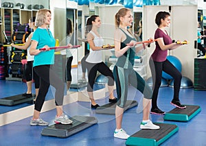 Positive females working out on aerobic step platform