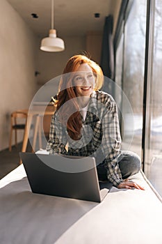 Positive freelance employee woman working at home, using laptop, thinking over online project future vision, job success