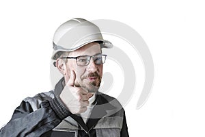 Positive friendly bearded male builder in overalls, hardhat and goggles showing thumbs up. Isolated background