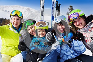 Positive friends with kid together wear ski masks