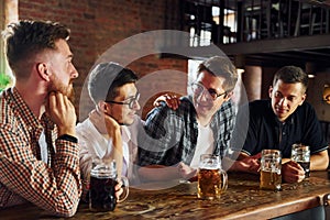 Positive friends. People in casual clothes sitting in the pub