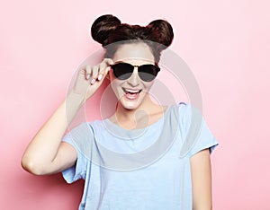 Positive funny brunette girl with hairbuns wearing sunglasses